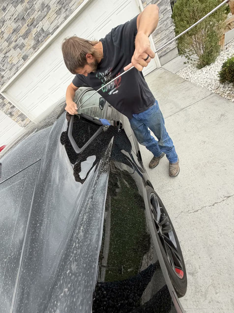 David opening a locked car with a rod tool, automotive locksmith service